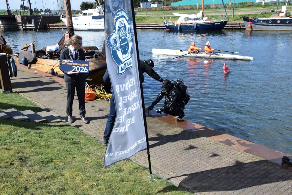 Het duikteam haalt het bord Opening watersportseizoen 2026 boven in de Stadshaven