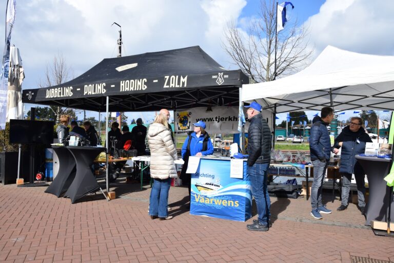 Kramen en stands aan de kade tijdens de opening van het watersportseizoen