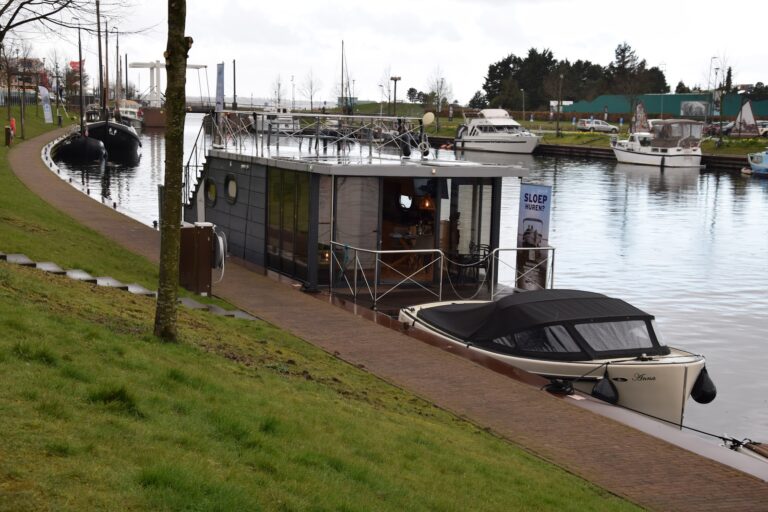 Sloep en woonboot aan de groene kade